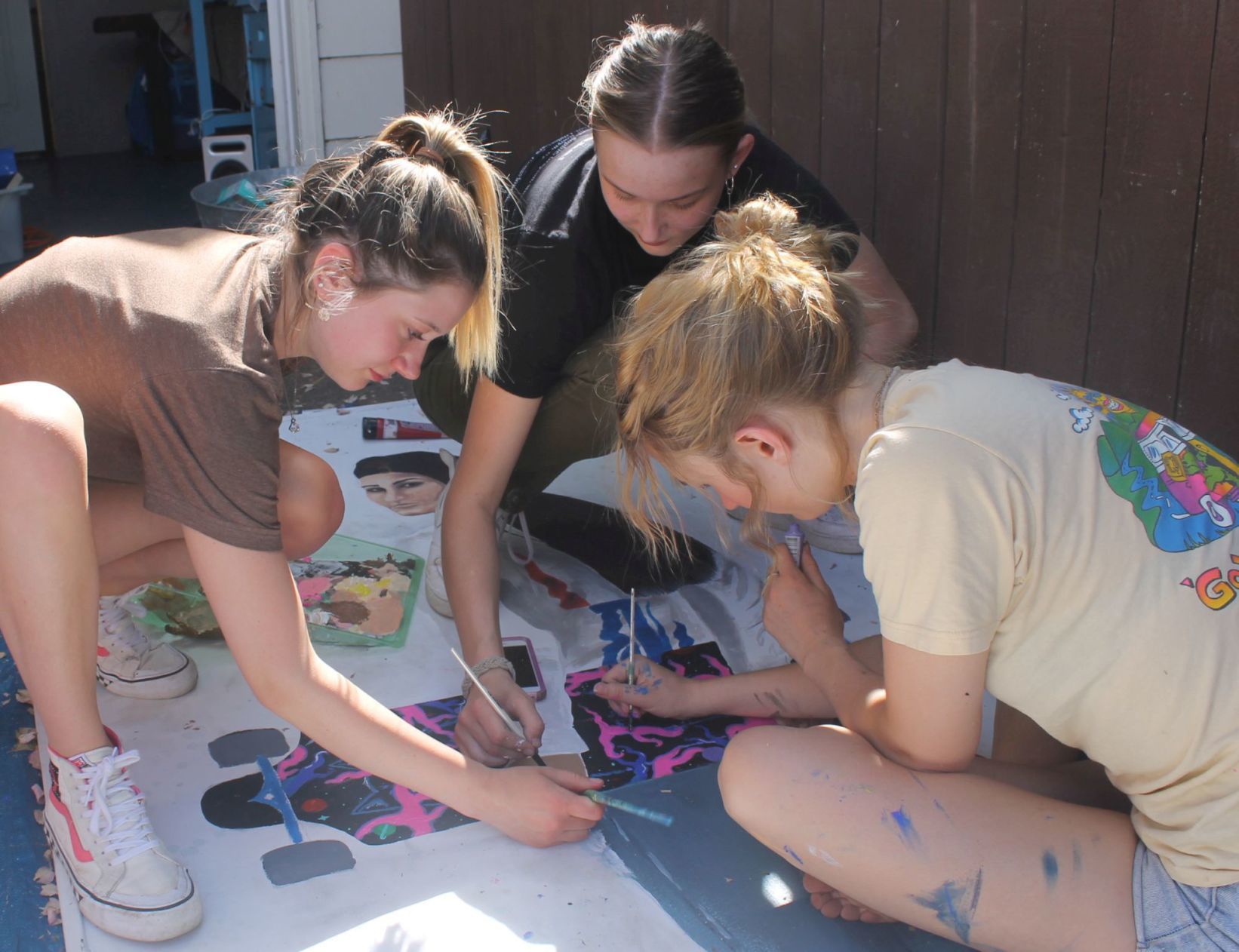 Teens work on Emma Fife's mural